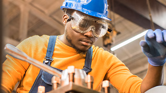 A person wearing a hard hat and goggles